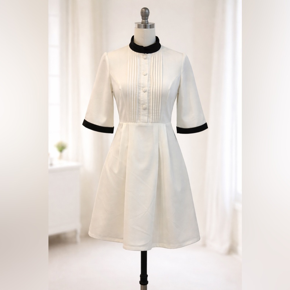 White formal dress with black cuffs and standing collar.